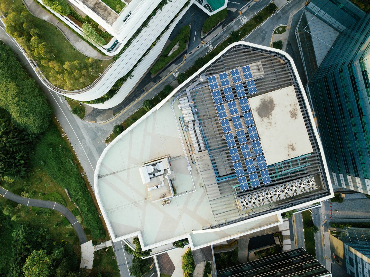 Solar panels on a green building roof with winding pathways.